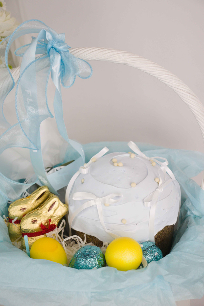 Close-up of white ranunculus Easter basket with yellow eggs and gold chocolates — Floritta