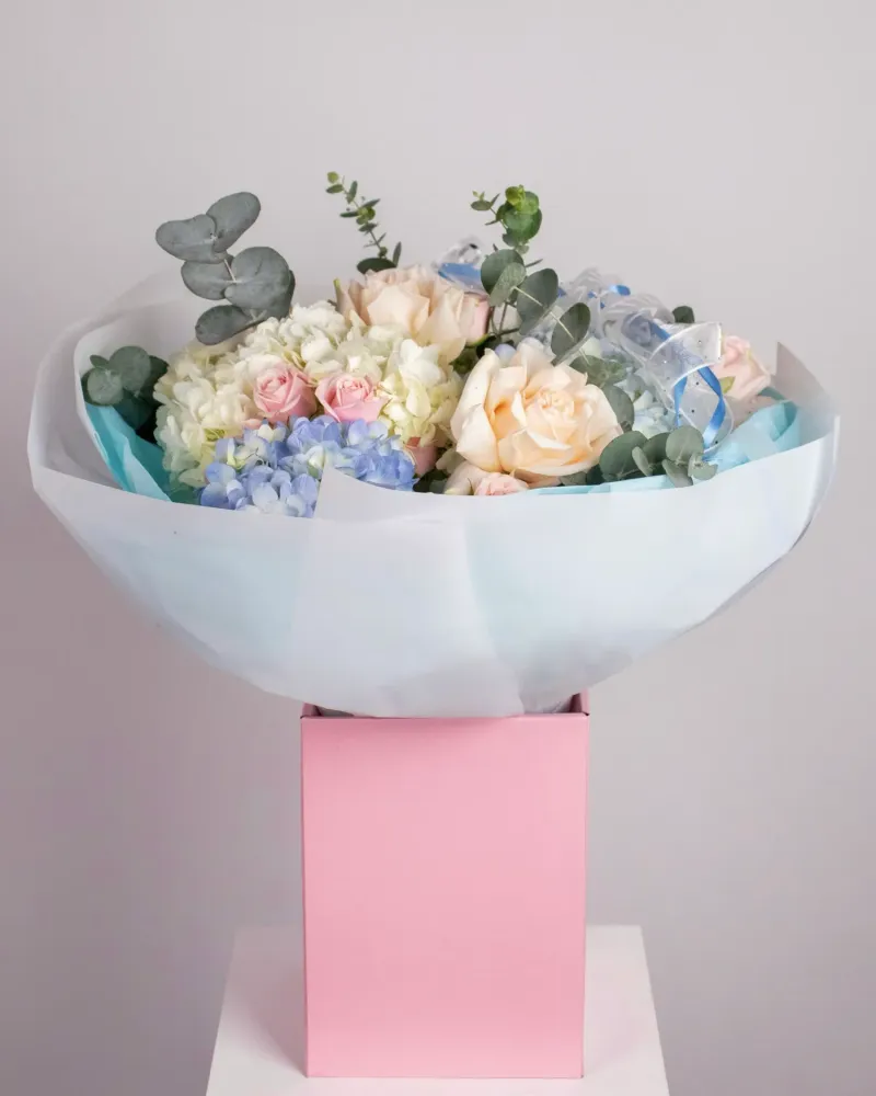 Cream and pale pink roses with blue hydrangeas and eucalyptus in white ceramic bowl vase — Floritta