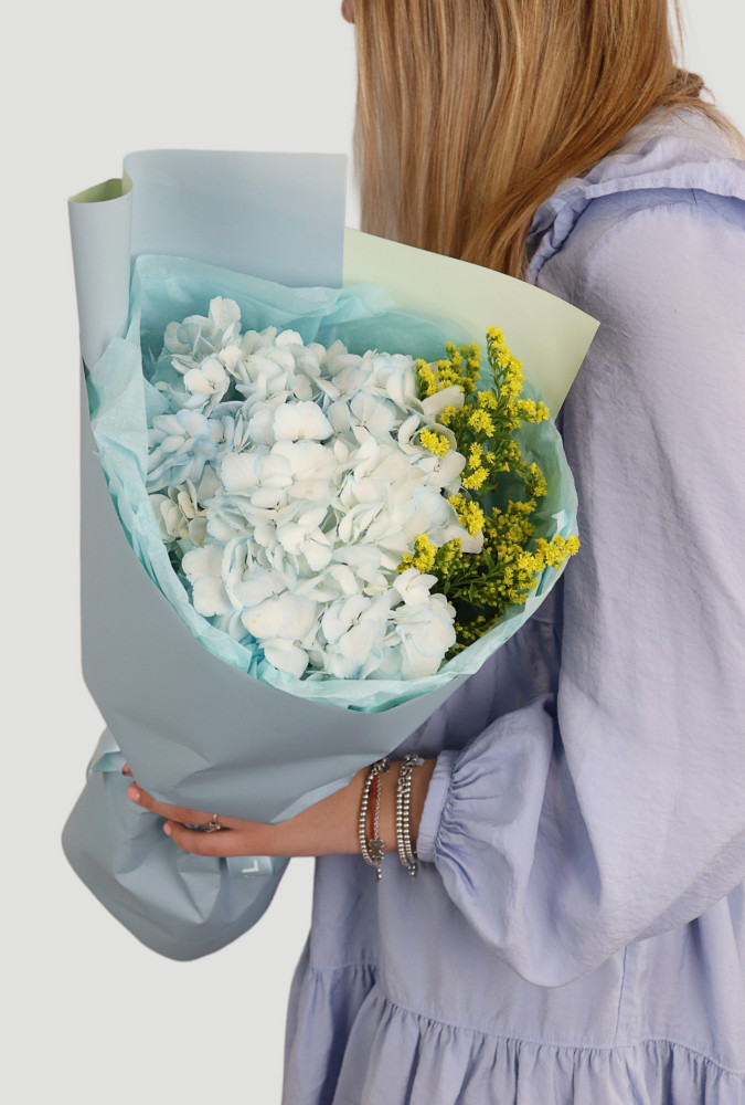 Luxe white hydrangea and yellow solidago bouquet wrapped in soft blue — Floritta