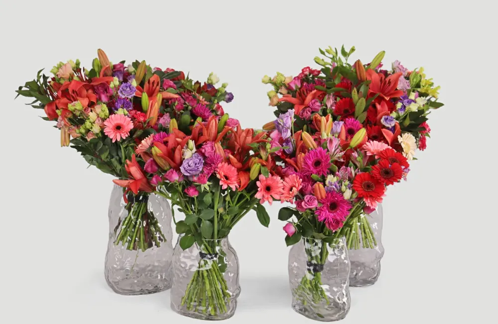 Vibrant bouquet of lilies, gerberas and roses in clear glass vase — Floritta