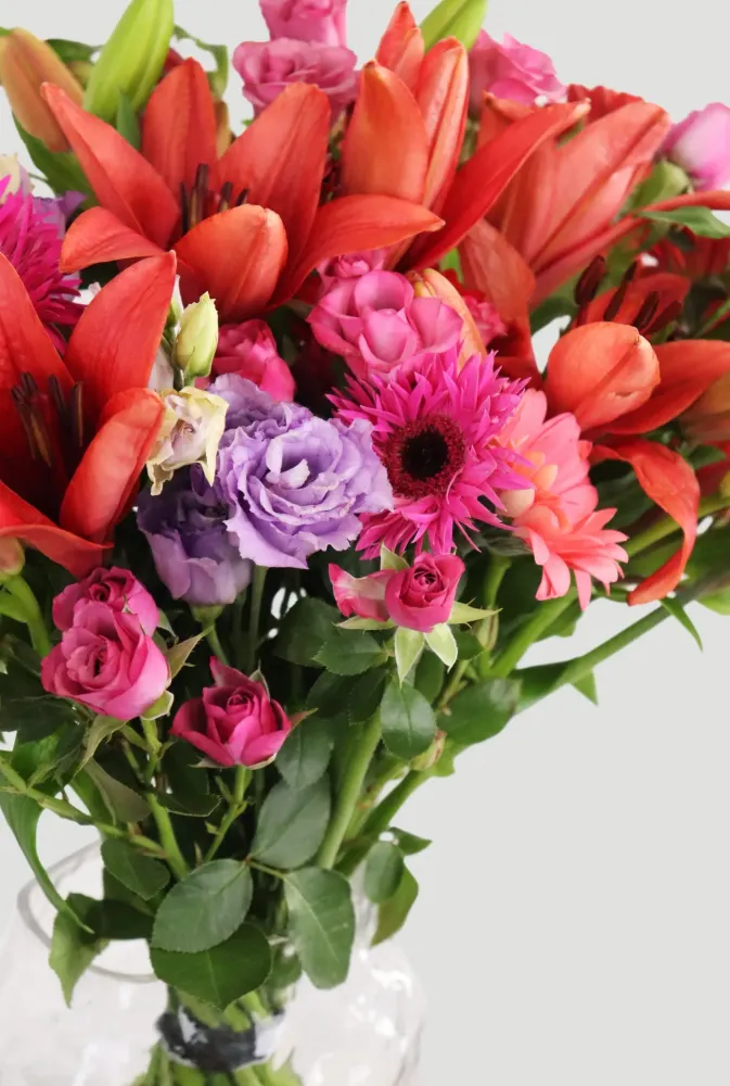 Colourful mixed arrangement with red lilies, pink gerberas and purple roses — Floritta