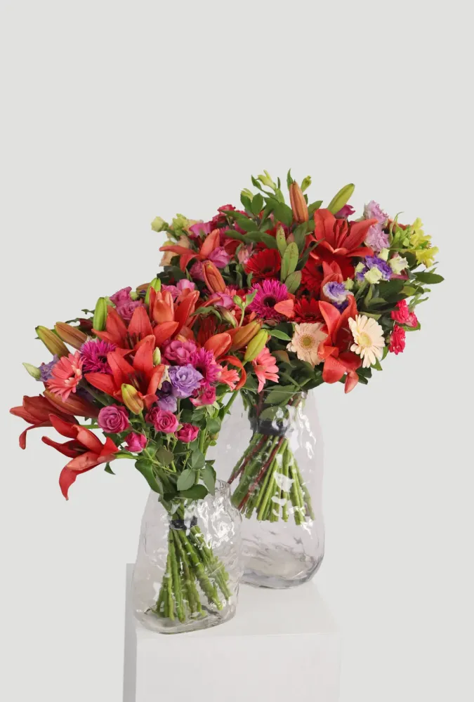 Bright multicoloured bouquet of lilies, gerberas and carnations in glass vase — Floritta