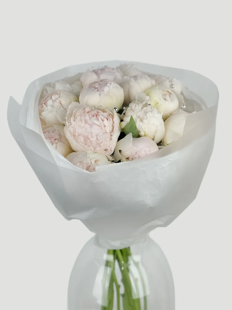 Luxurious bouquet of ivory and blush peonies wrapped in white tissue — Floritta