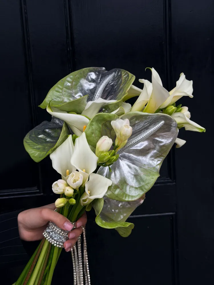 Luxe white calla and freesia bouquet with silvery anthurium foliage — Floritta