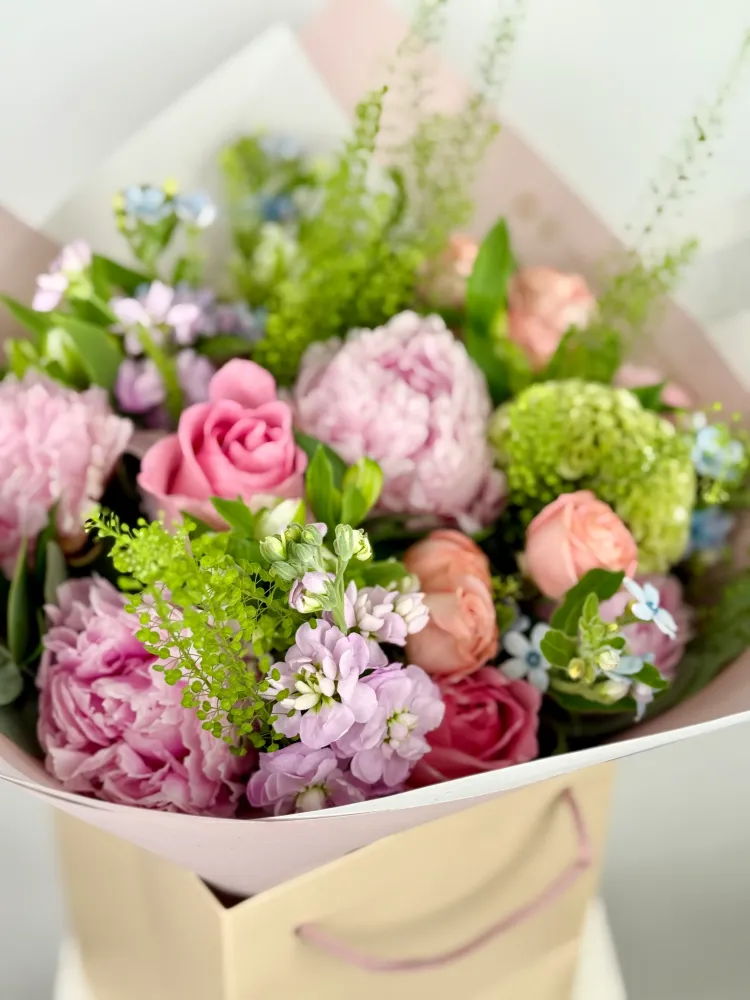 Pink and coral garden roses with peonies, greenery and forget-me-nots in cream wrap — Floritta