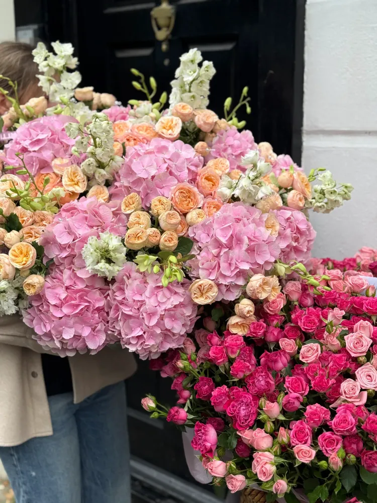 Magenta and blush spray roses in full wicker basket arrangement — Floritta