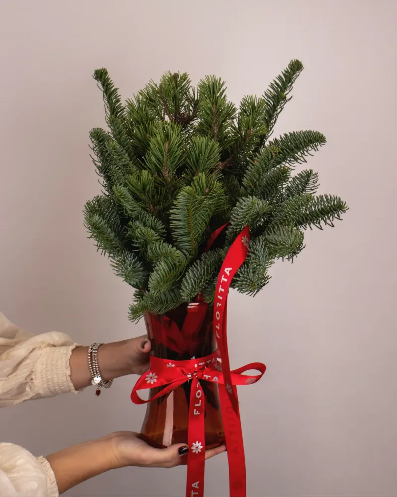 Lush conifer and evergreen bouquet tied with red Floritta ribbon — festive greenery