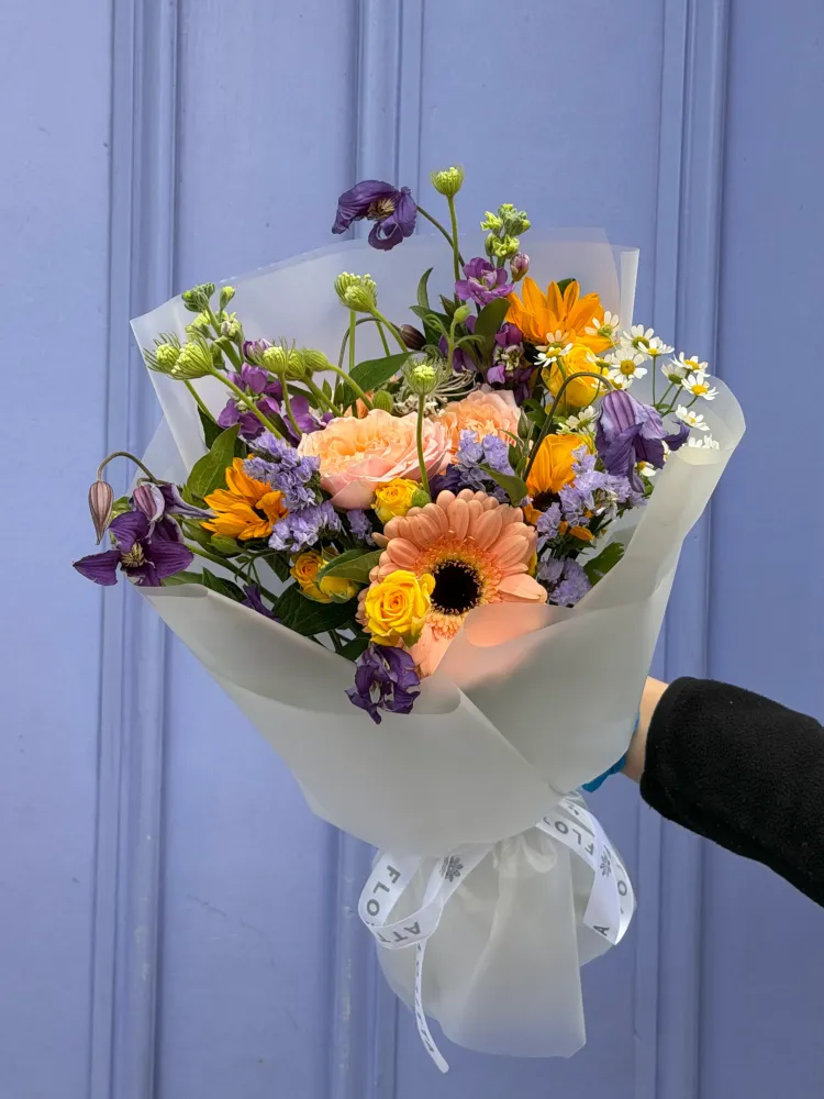 Vibrant bouquet of peach roses, orange gerberas, and purple lisianthus — Floritta