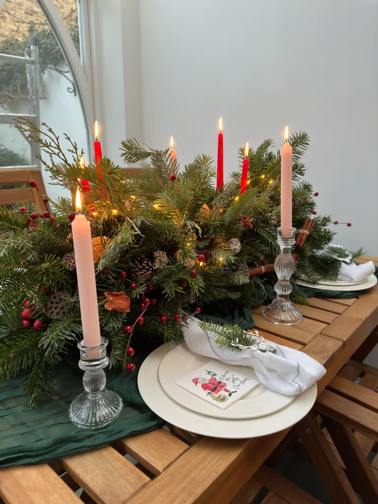 Festive Christmas table centrepiece with pine, hypericum and lit candles — Floritta