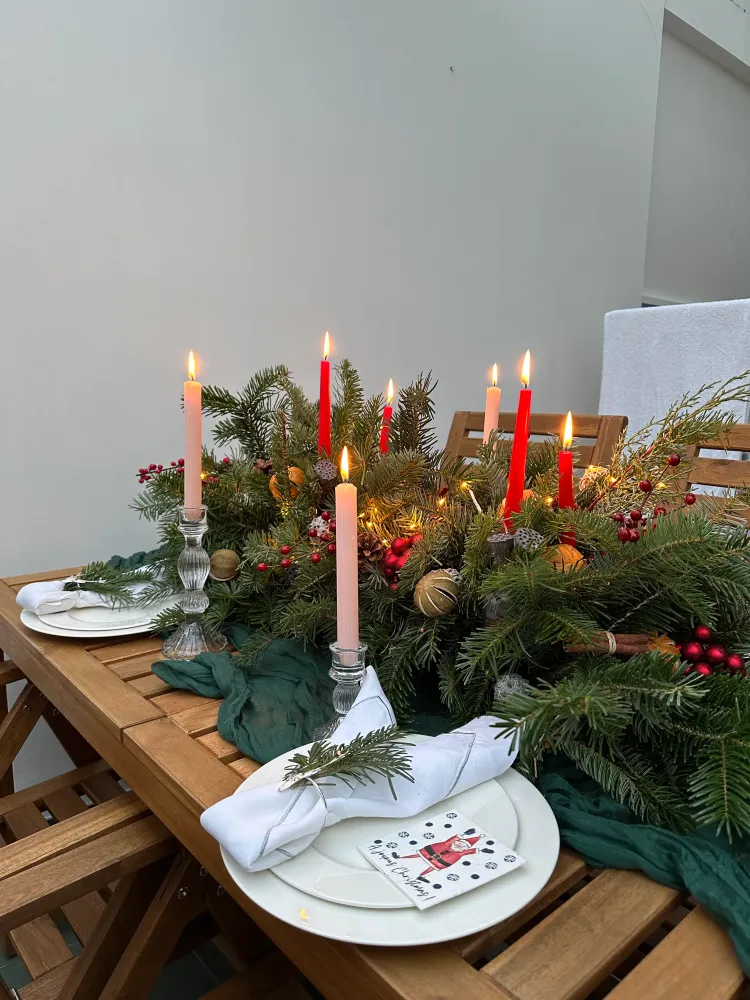 Lush evergreen centrepiece with red and blush candles, berries and gold accents — Floritta