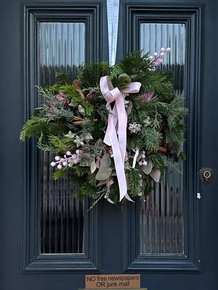 Festive wreath with pink skimmia berries, evergreen foliage and blush ribbon — Floritta
