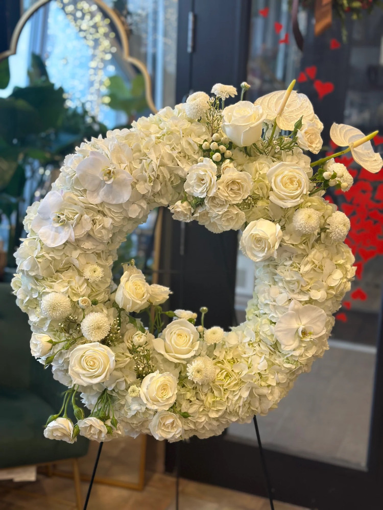 Cream and white hydrangea wreath with roses and orchids for Floritta — sympathy funeral tribute