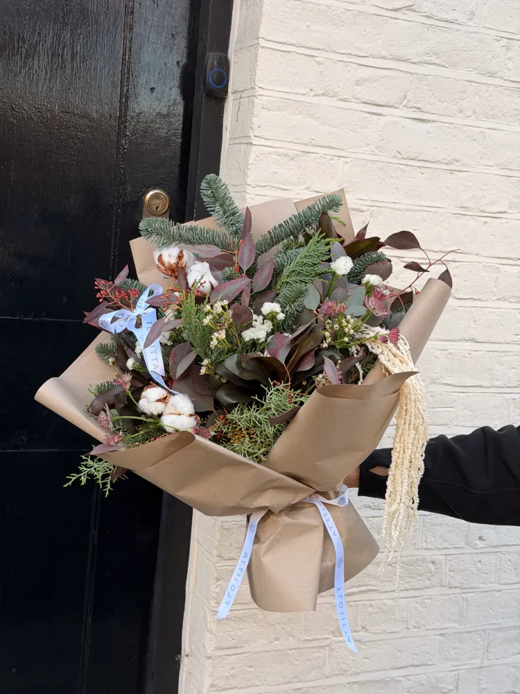 Textured winter bouquet with white astilbe, cotton and burgundy hypericum in kraft wrap—Floritta