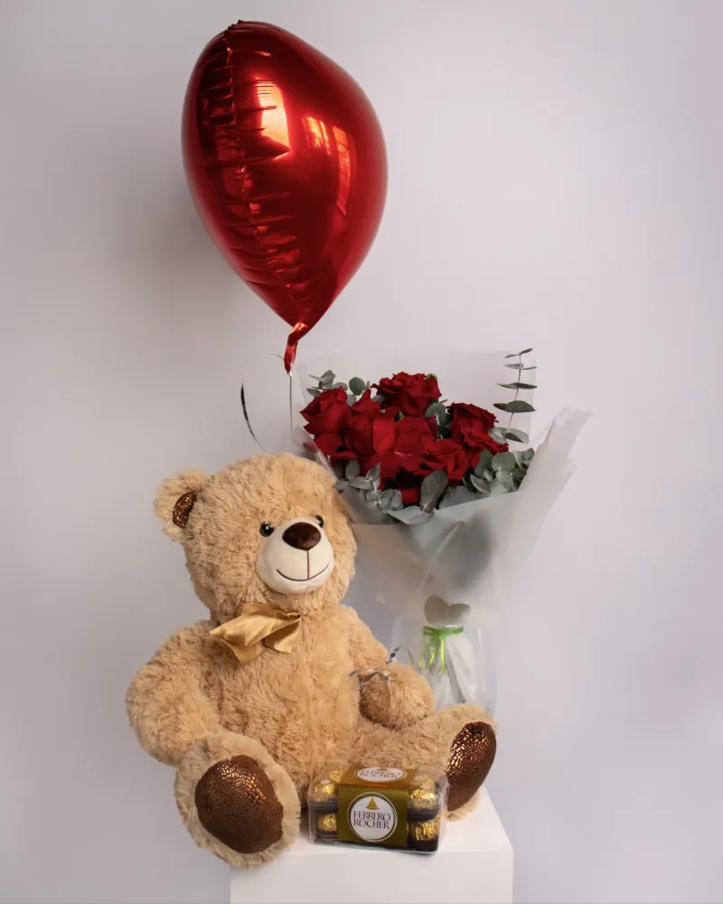 Romantic gift set with teddy bear, red roses, chocolate, and heart balloon