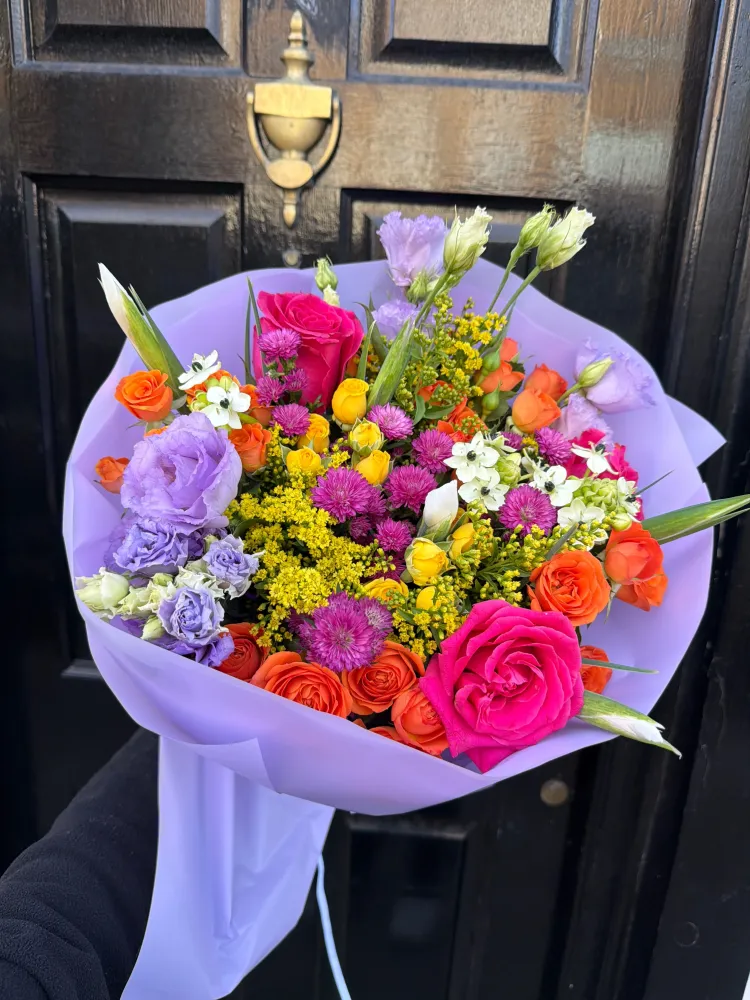 Vibrant mixed bouquet of roses, lisianthus and gerberas in lavender wrap — Floritta