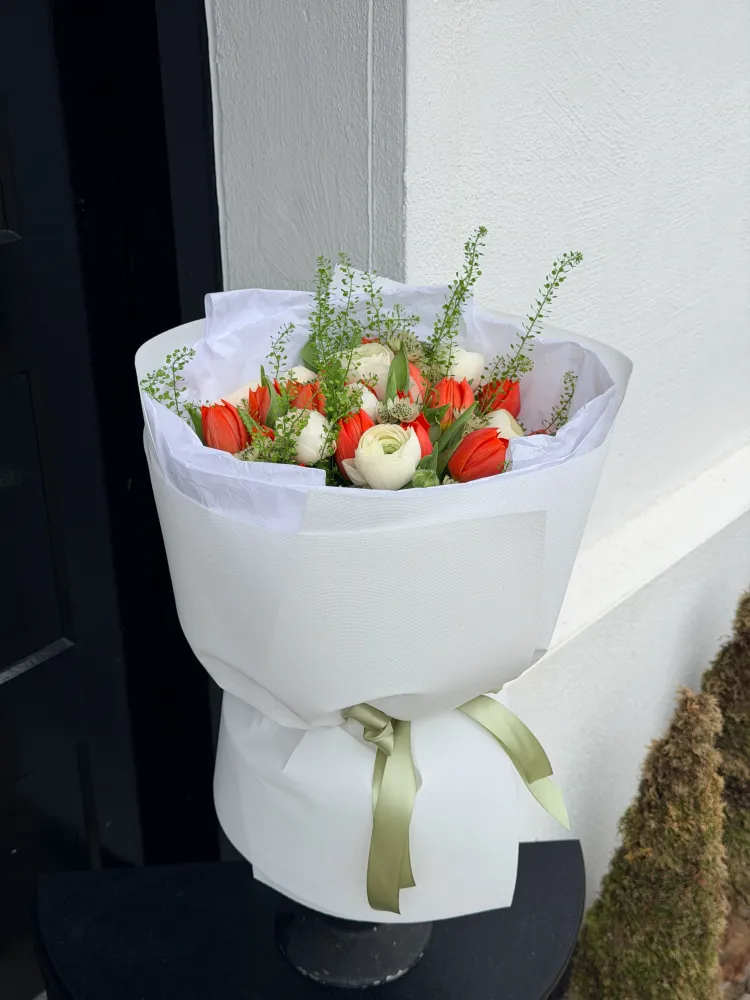 Red tulips, white ranunculus and seasonal greenery in white wrap — Floritta