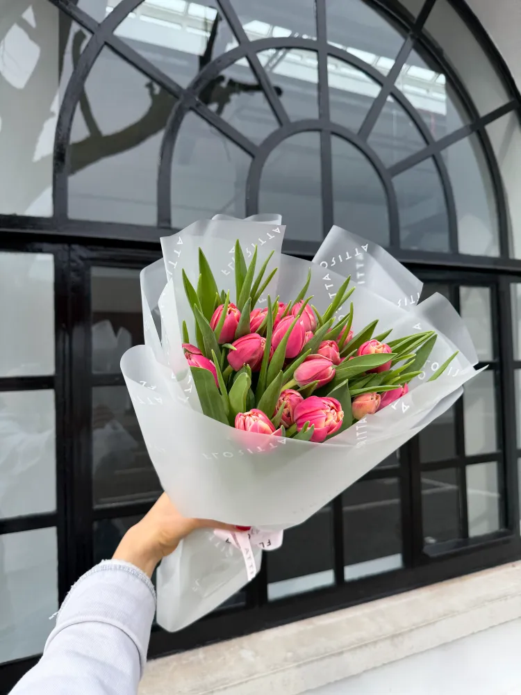 Hot pink tulips with lush green foliage in white paper wrap — Floritta