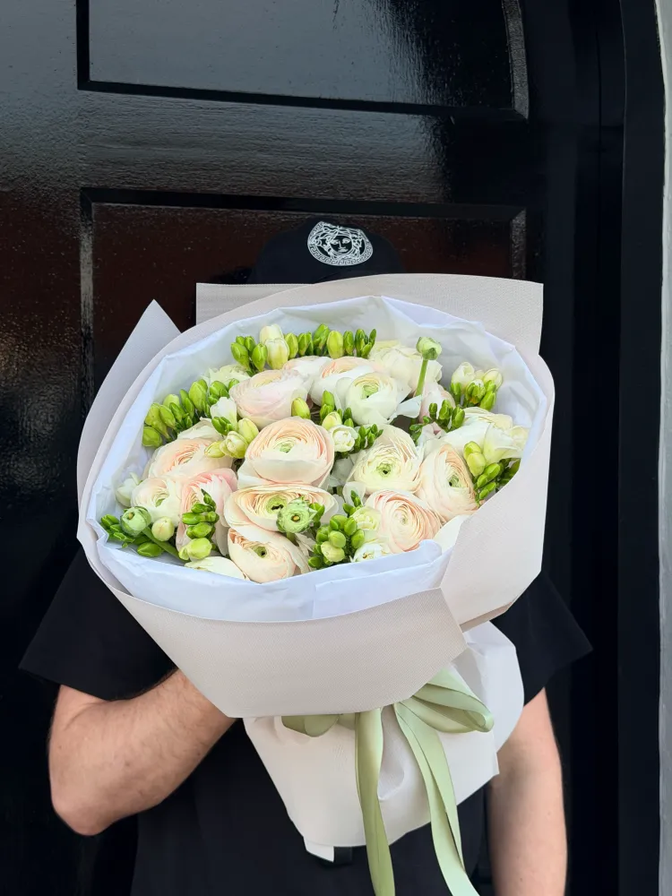 Elegant hand-tied posy of blush ranunculus and green skimmia in kraft paper — Floritta