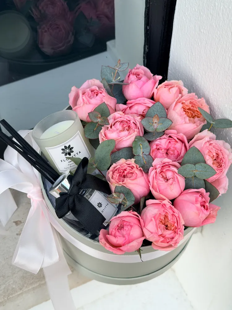 Luxurious pink garden roses with eucalyptus, cream hatbox and candle — Floritta