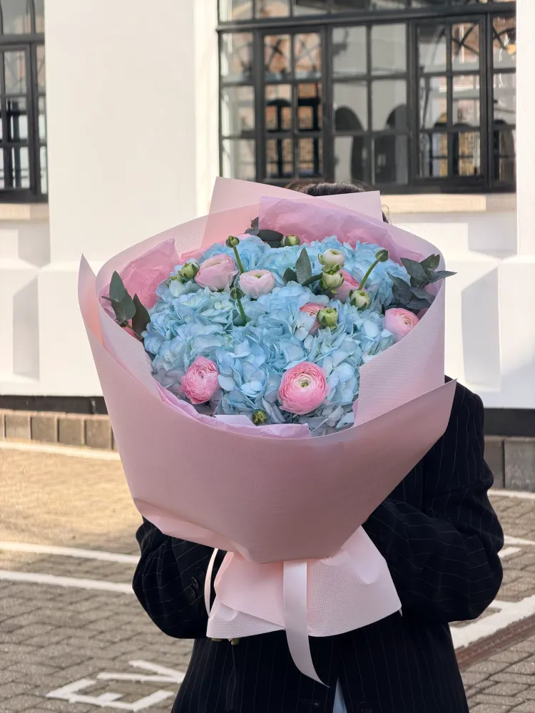 Pale blue hydrangea and pink ranunculus bouquet in soft pink wrap — Floritta