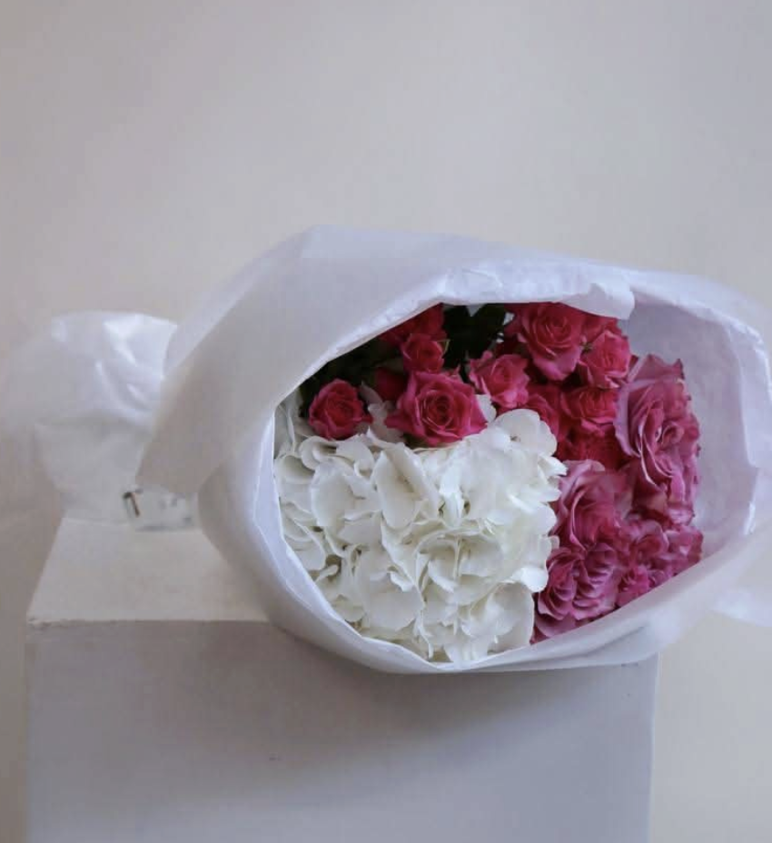 Full pink roses and white hydrangeas in white paper wrap — Floritta