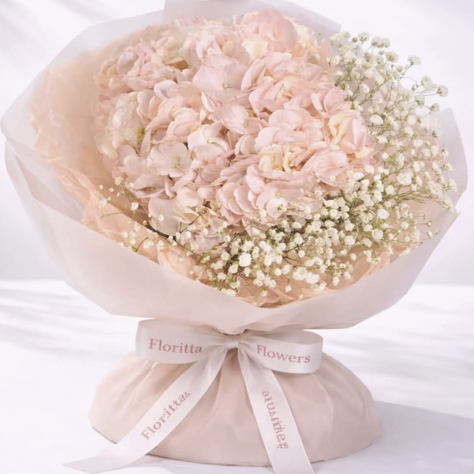 Blush hydrangea and baby's breath bouquet with tissue wrap — Floritta