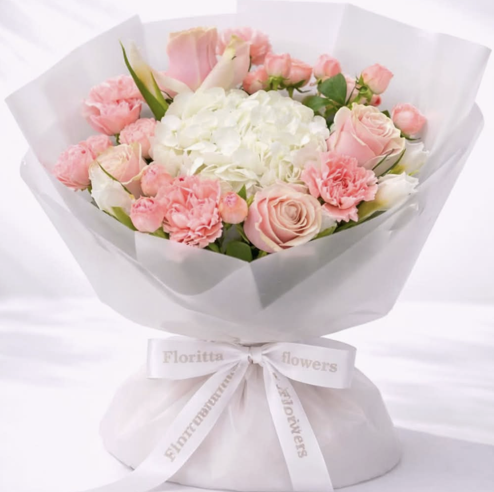 Elegant bouquet of white hydrangea, pink roses and carnations wrapped in white paper — Floritta