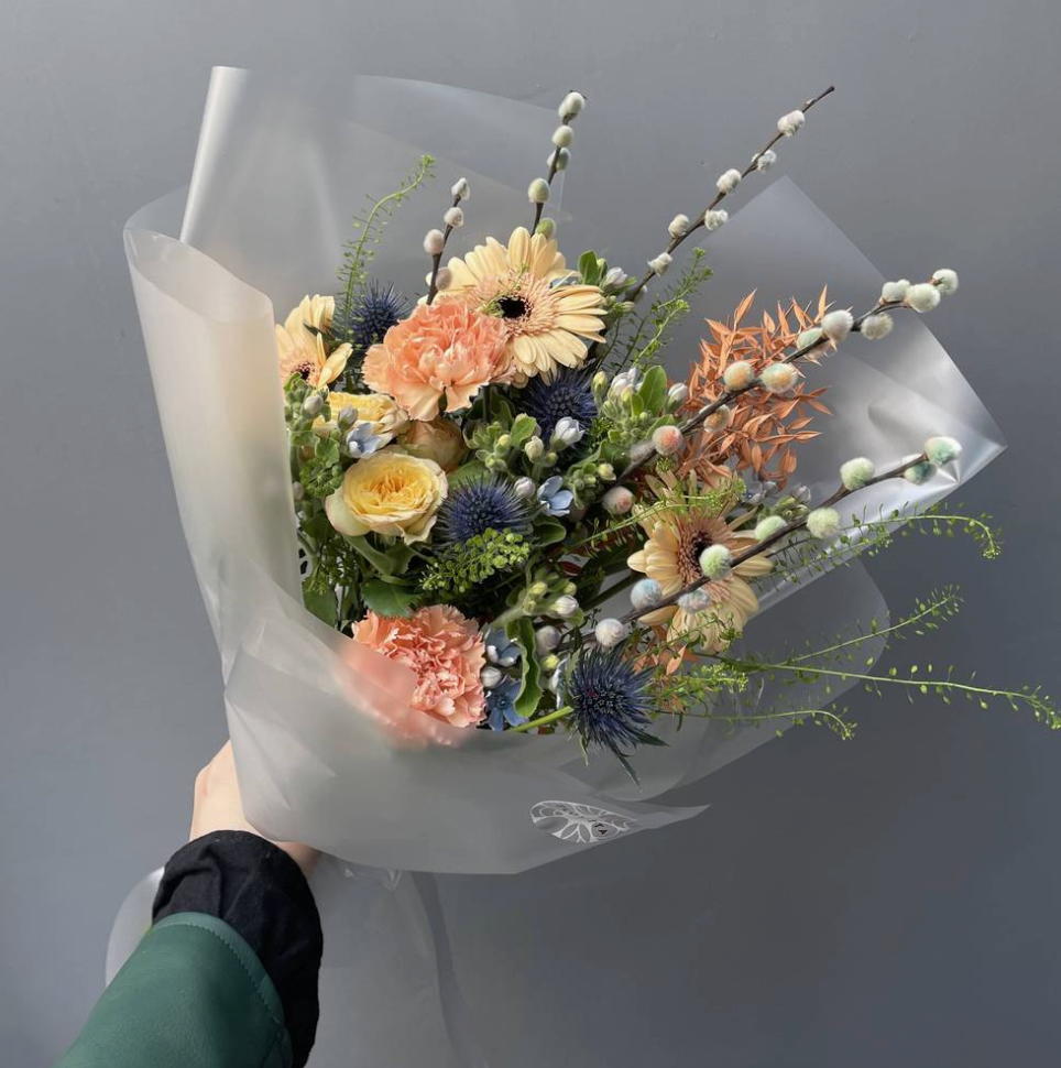 Peach gerbera and carnation bouquet with echinops and hypericum in white wrap — Floritta
