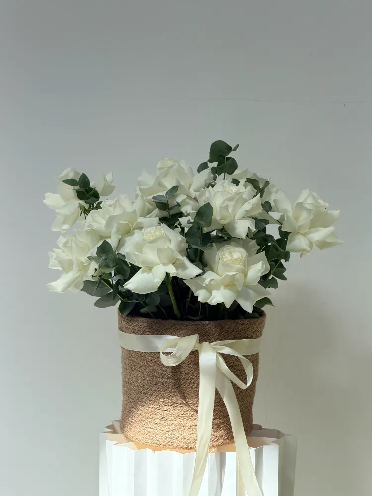 Lush white garden roses and eucalyptus in kraft wrap with cream ribbon — Floritta