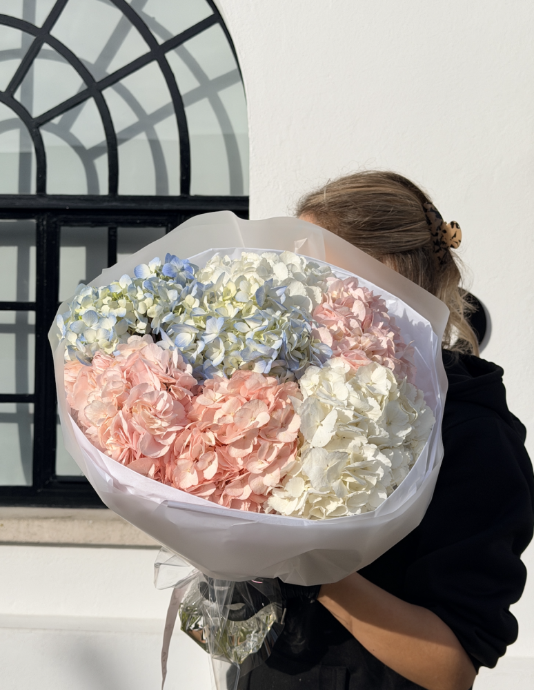 Lush hydrangea bouquet in soft pink, blue and cream with white tissue wrap — Floritta