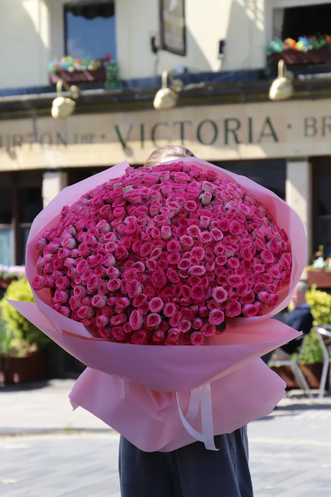Luxurious hand-tied bouquet of full pink and magenta roses in tissue wrap — Floritta
