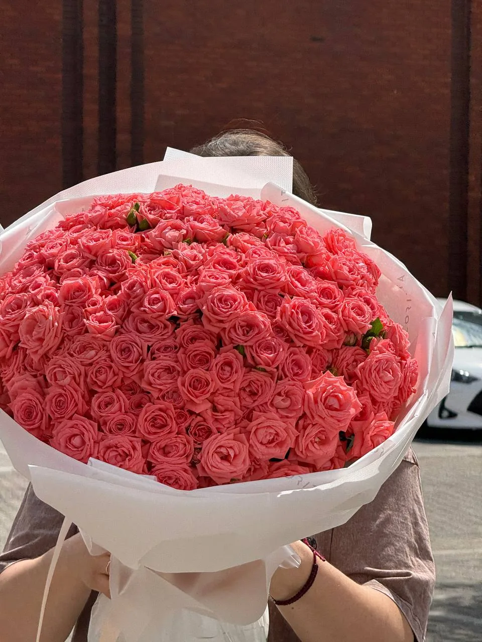 Coral spray roses bouquet in white wrap