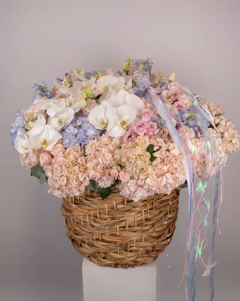 Luxe arrangement of white orchids, hydrangeas and roses in woven basket — Floritta