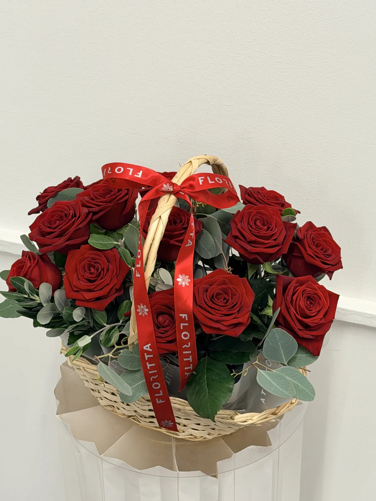 Scarlet wicker basket of red roses & eucalyptus