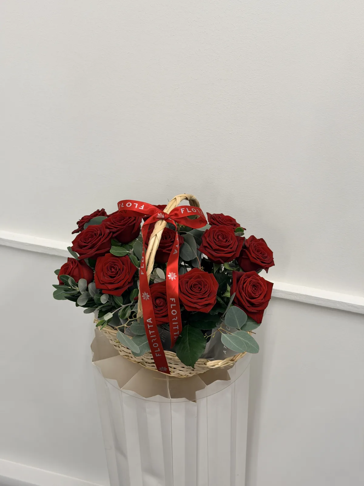 Scarlet wicker basket of red roses & eucalyptus