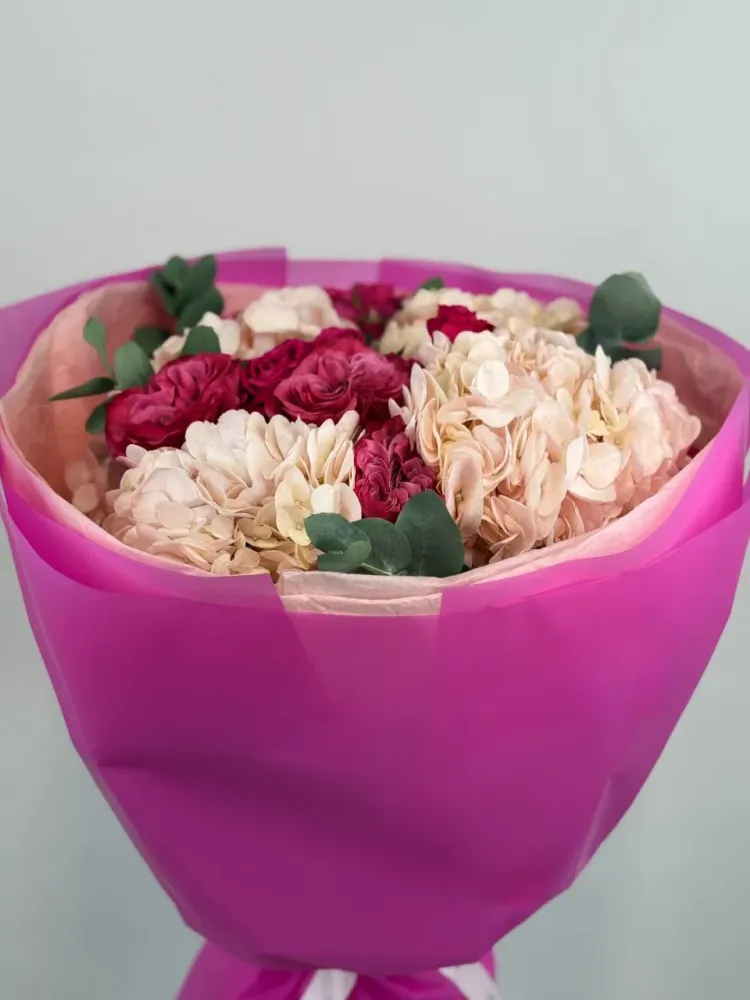 Luxe cream and burgundy rose arrangement in vibrant pink wrap — Floritta