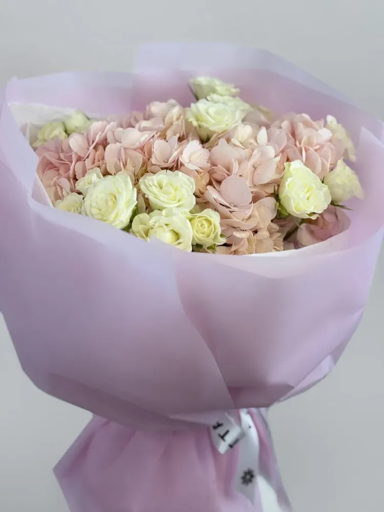 Cream and pale yellow roses with blush hydrangeas in pink wrap — Floritta